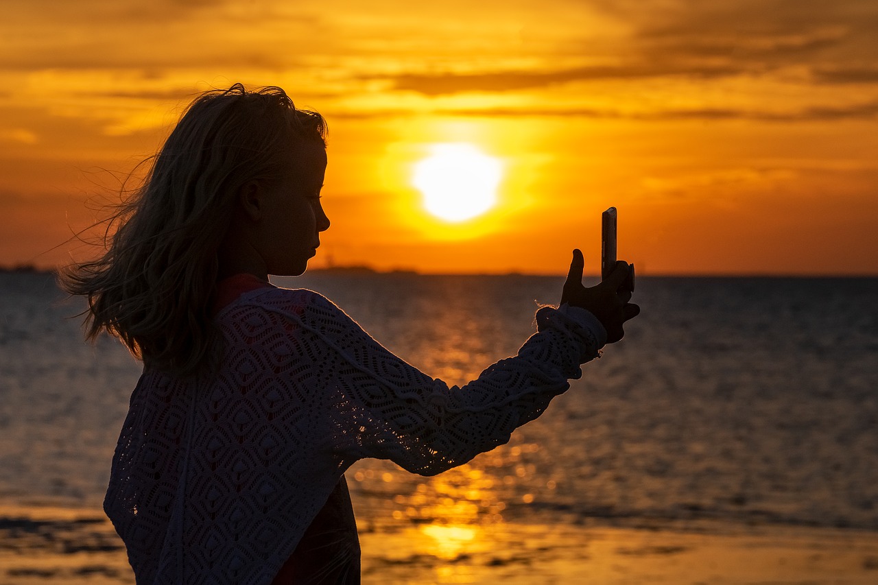 Une jeune fille de prend en photo sur la plage