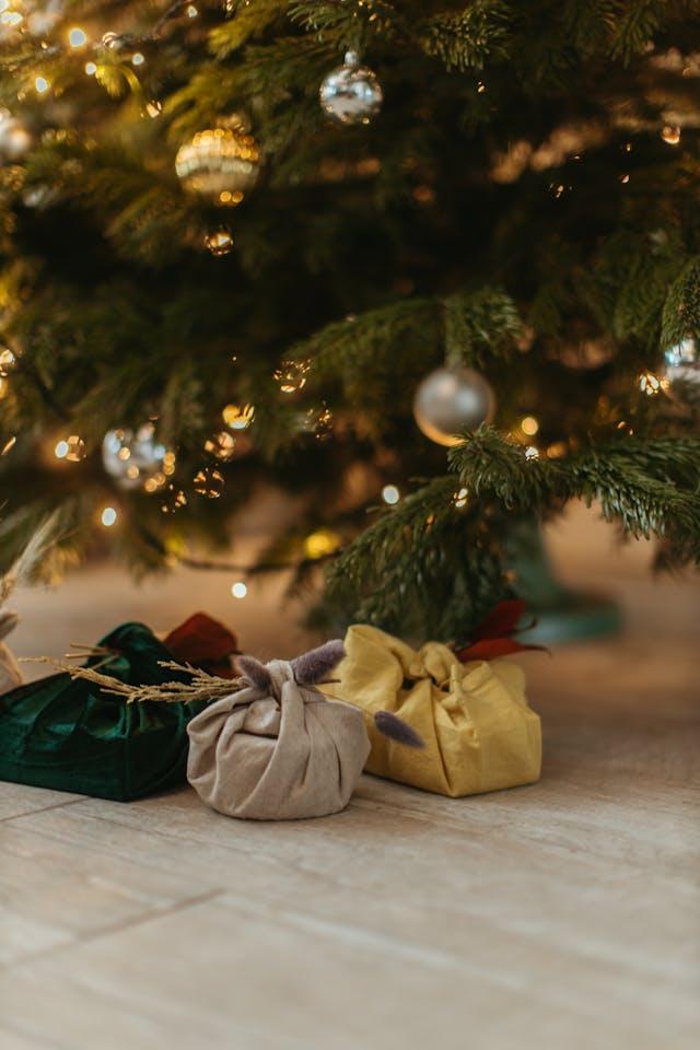 Cadeaux emballés dans des furoshiki sous un sapin de Noel