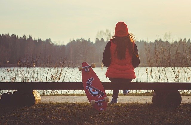 Femme assise sur un banc au bord d'un lac