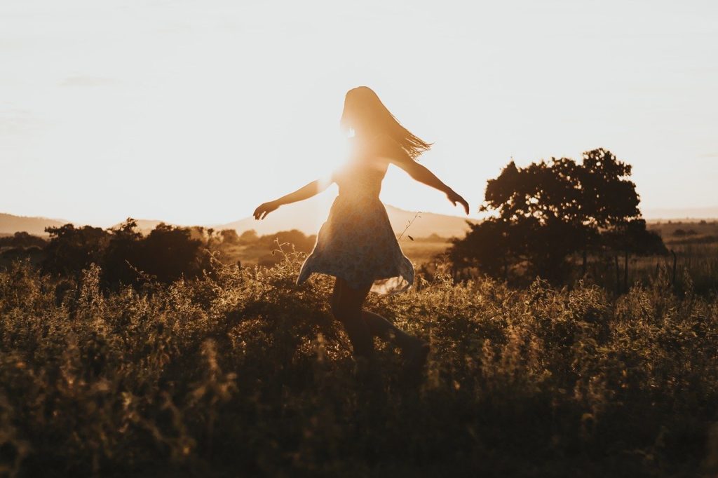 Femme joyeuse qui tourne sur elle-même dans la nature