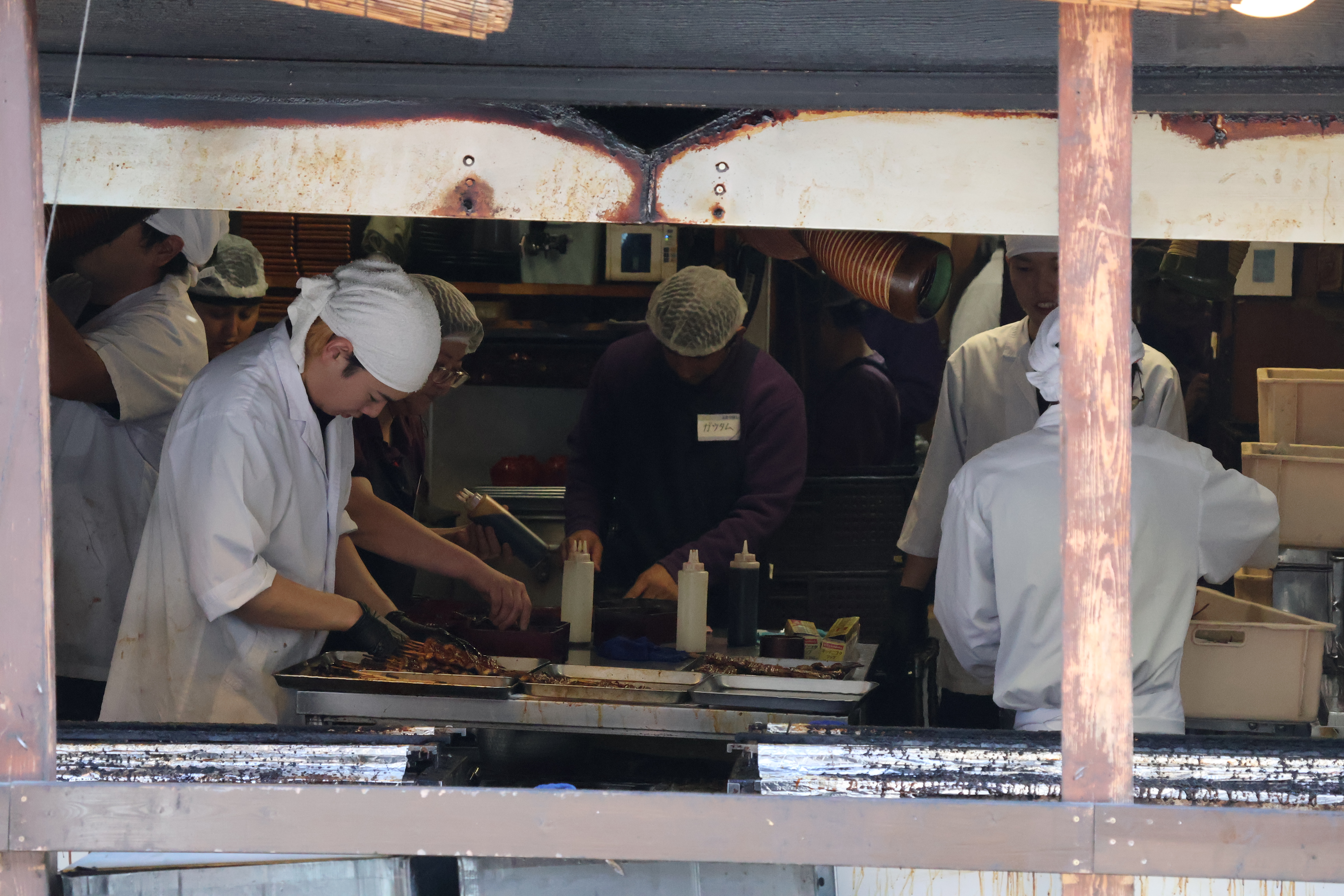 Cuisiniers visibles depuis la rue en train de cuire des anguilles